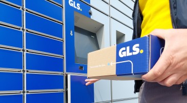 The picture shows a parcel being picked up from a parcel locker.